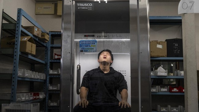 Konoe employee Taichi Konishi takes a break in a cooling box for workers also known as a