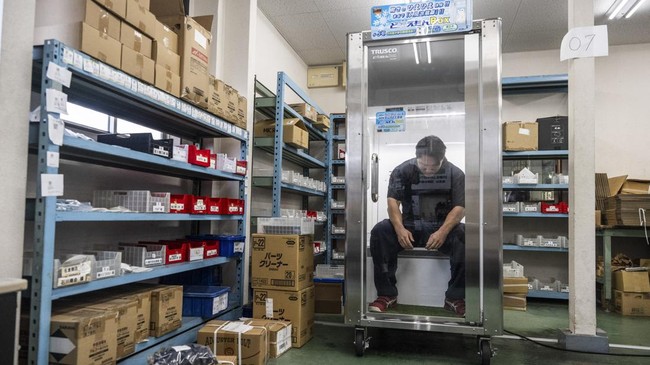 Konoe employee Taichi Konishi takes a break in a cooling box for workers also known as a