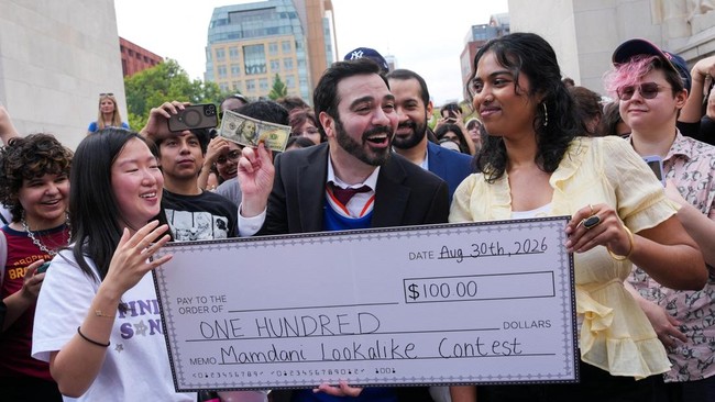 Amadeo Fusca holds the one hundred dollar prize after winning a New York City Mayor Zohran Mamdani lookalike contest at Washington Square Park in New York City, U.S., August 30, 2026. REUTERS/Adam Gray