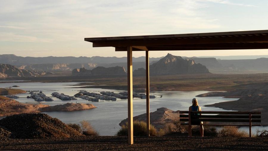Seorang wanita menyaksikan matahari terbit (tidak terlihat dalam foto) di atas Wahweap Marina di Danau Powell, saat waduk vital tersebut berada pada tingkat permukaan air terendah yang pernah tercatat, di Glen Canyon National Recreation Area dekat Page, Arizona, AS, pada 30 Agustus 2026.