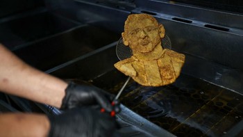 Chef Damian Zanotti, who works at the restaurant El Antojo, cooks a schnitzel, known as milanesa in Argentina, with the face of Argentina's soccer legend Lionel Messi, a day after he announced his retirement from the national team, in Buenos Aires, A