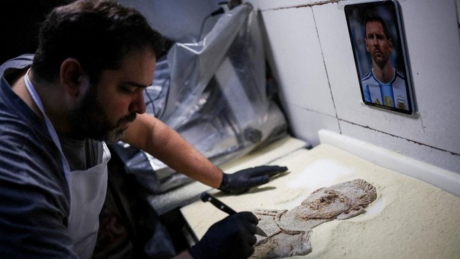 Chef Damian Zanotti, who works at the restaurant El Antojo, prepares a schnitzel, known as milanesa in Argentina, with the face of Argentina's soccer legend Lionel Messi, a day after he announced his retirement from the national team, in Buenos Aires