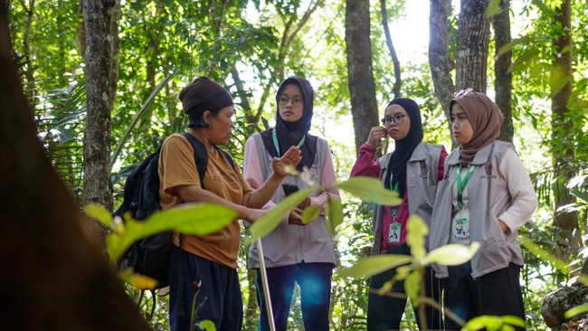 Tini Kasmawati memberikan penjelasan kepada mahasiswi yang ingin mempelajari tentang owa jawa di Desa Lengkong, Kabupaten Sukabumi, Jawa Barat.