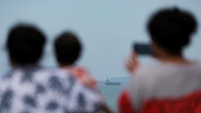 People watch as the U.S. Navy Nimitz-class aircraft carrier USS Abraham Lincoln sails toward Laem Chabang Port before docking for a rest stop following a long deployment in the Middle East, in Chonburi province, Thailand, September 2, 2026. REUTERS/C