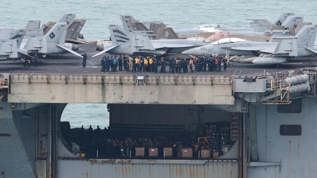 Personnel and aircraft on the deck of the U.S. Navy Nimitz-class aircraft carrier USS Abraham Lincoln as it sails toward Laem Chabang Port before docking for a rest stop following a long deployment in the Middle East, in Chonburi province, Thailand,