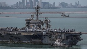The U.S. Navy Nimitz-class aircraft carrier USS Abraham Lincoln sails toward Laem Chabang Port before docking for a rest stop following a long deployment in the Middle East, with the Pattaya skyline in backdrop, in Chonburi province, Thailand, Septem