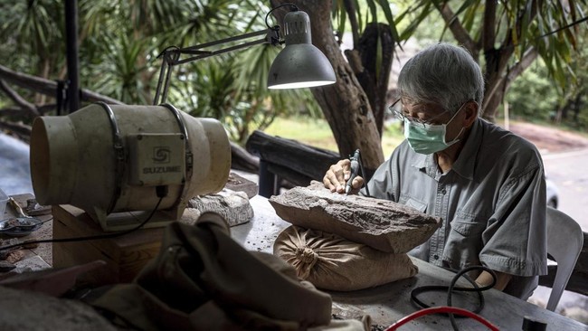 Palaeontologist Varavudh Suteethorn uses a pneumatic pen to excavate a dinosaur fossil at Phu Wiang National Park in Khon Kaen on August 19, 2026. Researchers have found a trove of dinosaur fossils in Khon Kaeon province, which holds the country's ri
