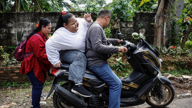 ntan Permatasari gets onto the back of a motorcycle after a medical appointment in Bogor, West Java province, Indonesia, August 21, 2025. Bullied relentlessly by classmates as her struggles with obesity intensified, Intan quit school aged 12 and stay