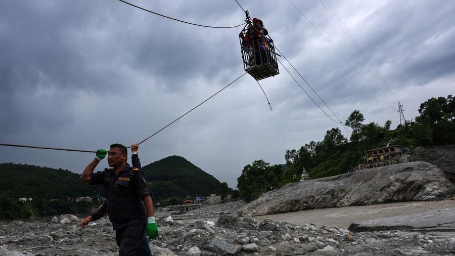 Sejumlah orang berada di dalam keranjang yang digantung pada tali luncur (zip line) darurat saat menyeberangi Sungai Trishuli dari Koloni, menyusul banjir bandang mematikan yang merusak jembatan dan sempat membuat warga terisolasi, di distrik Nuwakot, Nepal, pada 3 September 2026. Sejumlah orang berada di dalam keranjang yang digantung pada tali luncur (zip line) darurat saat menyeberangi Sungai Trishuli dari Koloni, menyusul banjir bandang mematikan yang merusak jembatan dan sempat membuat warga terisolasi, di distrik Nuwakot