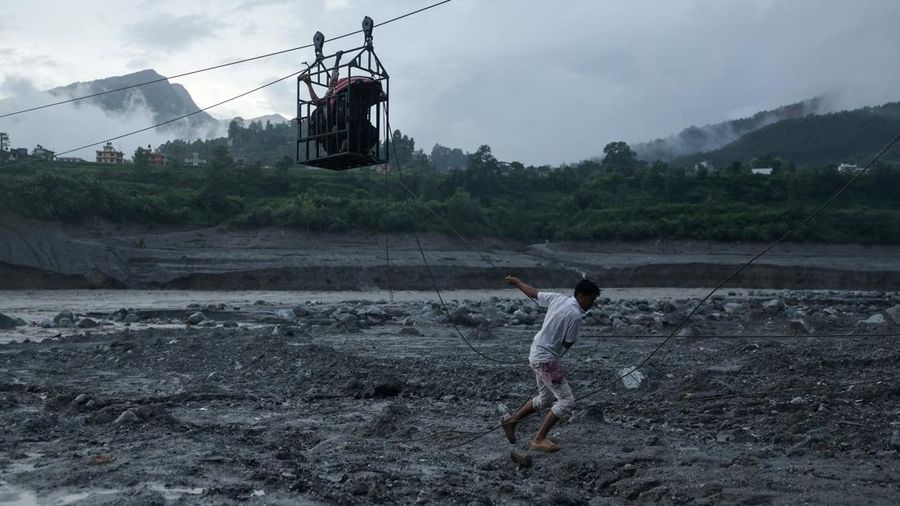 Seorang pria menarik tali luncur darurat yang membawa orang-orang menyeberangi Sungai Trishuli dari arah Koloni, setelah tanah longsor dan aliran lumpur merusak jembatan serta menyebabkan warga sempat terjebak di Trishuli, Distrik Nuwakot, Nepal, pada 2 September 2026. Seorang pria menarik tali luncur darurat yang membawa orang-orang menyeberangi Sungai Trishuli dari arah Koloni, setelah tanah longsor dan aliran lumpur merusak jembatan serta menyebabkan warga sempat terjebak di Trishuli, Distrik Nuwakot, Nepal, pada 2 September 2026.