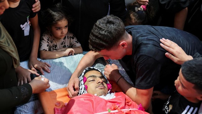 SENSITIVE MATERIAL. THIS IMAGE MAY OFFEND OR DISTURB    Mourners gather near the body of Khalil Abu Alia, one of the two Palestinians killed during a militant settlers' attack on their village, during his funeral procession, in Al-Mughayyir, in the I