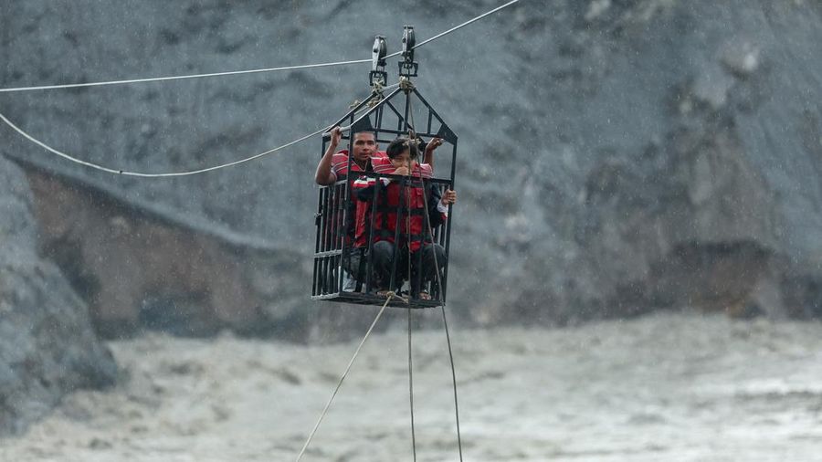 Warga berpegangan pada keranjang yang tergantung di jalur *zip-line* darurat saat menyeberangi Sungai Trishuli dari arah Koloni, setelah tanah longsor dan aliran lumpur merusak jembatan serta sempat membuat warga di Trishuli, Distrik Nuwakot, Nepal, terisolasi pada 2 September 2026. Warga berpegangan pada keranjang yang tergantung di jalur *zip-line* darurat saat menyeberangi Sungai Trishuli dari arah Koloni, setelah tanah longsor dan aliran lumpur merusak jembatan serta sempat membuat warga di Trishuli, Distrik Nuwakot, Nepal, terisolasi pada 2 September 2026.