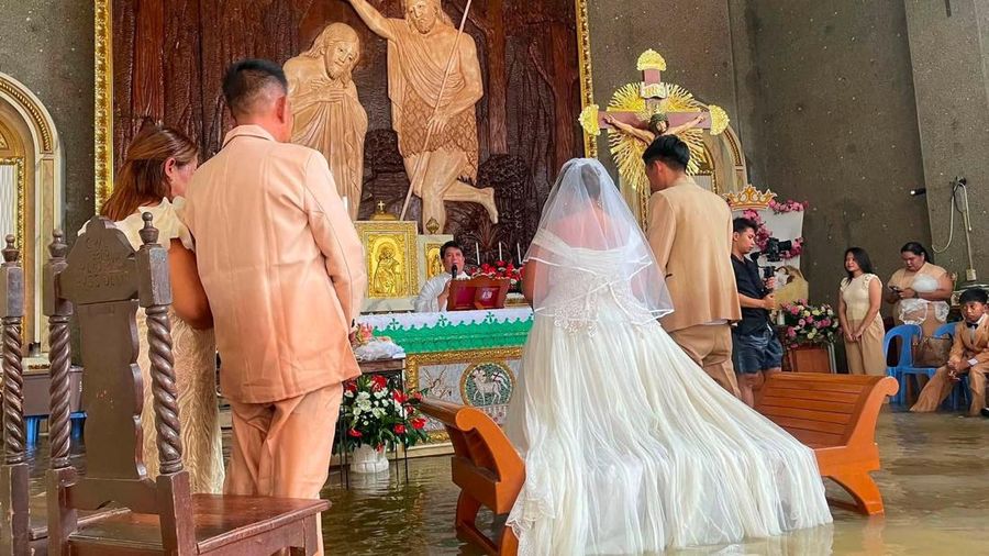 Sepasang kekasih asal Filipina melangsungkan pernikahan di tengah genangan banjir di Paroki St. John the Baptist di Hagonoy, Provinsi Bulacan, Filipina, pada 1 September 2026.