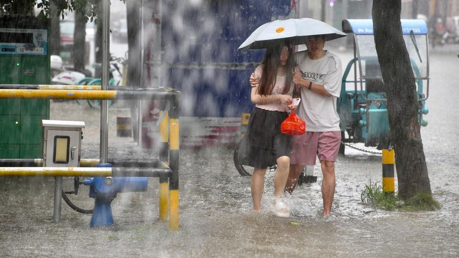 Warga melangkah menyusuri jalan nan tergenang banjir di tengah hujan deras di Fuzhou, Provinsi Fujian, China, Kamis (3/9/2026). (via REUTERS/cnsphoto)