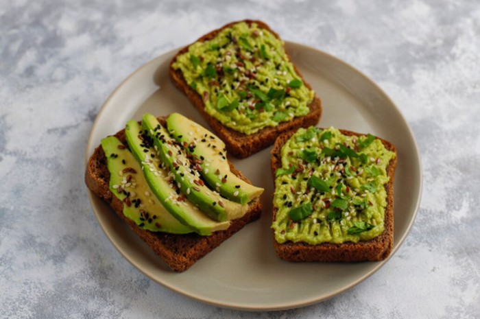 Avocado toast bisa menjadi menu sarapan yang lezat sekaligus kaya serat dan lemak sehat. Kombinasikan sourdough atau roti biji-bijian dengan alpukat, kacang-kacangan, atau biji-bijian untuk menu yang lebih lengkap./ Foto: magnific.com/BalashMirzabey