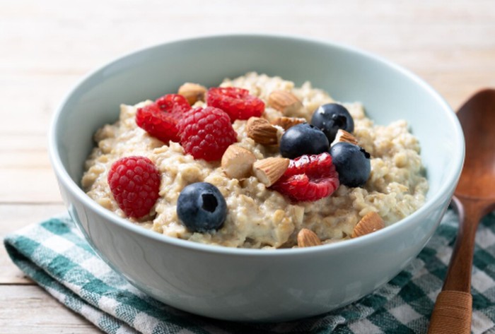 Oatmeal kaya akan gandum utuh dan serat yang baik untuk kesehatan pencernaan. Tambahkan Greek yogurt, buah segar, dan kenari untuk mendapatkan probiotik, antioksidan, serta lemak sehat./ Foto: magnific.com/chandlervid85