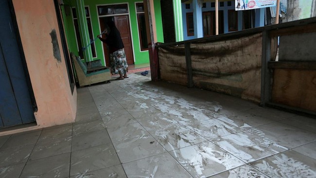 A woman sweeps a floor covered with volcanic ash at Pasauran village, following the Mount Anak Krakatau volcano eruption, in Serang, Banten province, Indonesia, September 6, 2026. REUTERS/Sammy