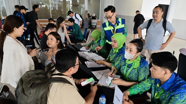 Petugas memberikan informasi kepada calon penumpang dari penerbangan terdampak di area Terminal Domestik Bandara Internasional I Gusti Ngurah Rai, Badung, Bali, Minggu (6/9/2026). Pengelola Bandara Bali mencatat hingga Minggu sore terdapat 42 penerba