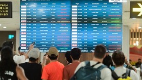 Sejumlah calon penumpang pesawat udara melihat informasi jadwal keberangkatan di area Terminal Domestik Bandara Internasional I Gusti Ngurah Rai, Badung, Bali, Minggu (6/9/2026). Pengelola Bandara Bali mencatat hingga Minggu sore terdapat 42 penerban