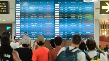 Sejumlah calon penumpang pesawat udara melihat informasi jadwal keberangkatan di area Terminal Domestik Bandara Internasional I Gusti Ngurah Rai, Badung, Bali, Minggu (6/9/2026). Pengelola Bandara Bali mencatat hingga Minggu sore terdapat 42 penerban