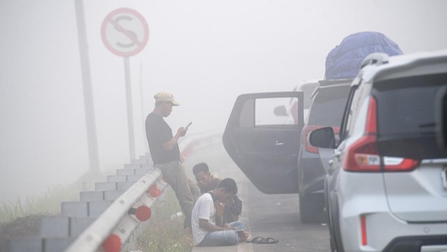 Sejumlah pengendara menunggu di gerbang tol Palembang Jalan Tol Trans Sumatera (JTTS) ruas Palembang-Prabumulih yang tertutup kabut asap di Pemulutan, Kabupaten Ogan Ilir (OI), Sumatera Selatan, Minggu (6/9/2026). PT Hutama Karya (Persero) selaku pen