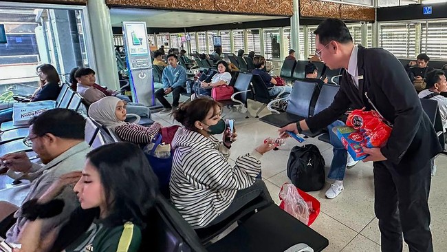 Petugas Bandara membagikan makanan ringan kepada calon penumpang terdampak penutupan sementara bandara di Terminal 3 Bandara Soekarno Hatta, Tangerang, Banten, Minggu (6/9/2026). PT Angkasa Pura Indonesia atau Injourney Airports mengaktifkan prosedur