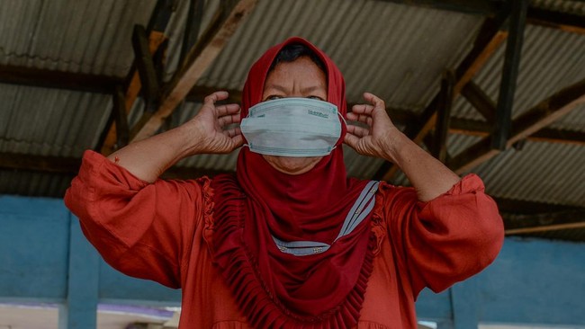 Warga mengenakan masker di Tempat Pelelangan Ikan Pasauran, Kabupaten Serang, Banten, Minggu (6/9/2026). Pembagian masker secara swadaya tersebut bertujuan untuk melindungi pernapasan warga dan nelayan setempat dari paparan abu vulkanik erupsi Gunung