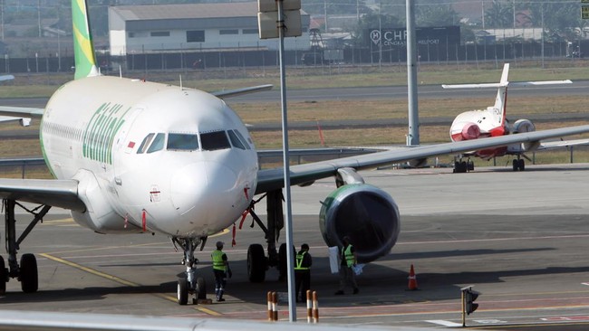 Petugas darat melakukan penutupan mesin pesawat yang terparkir dengan menggunakan bahan khusus di apron Terminal 1 C Bandara Soekarno Hatta, Tangerang, Banten, Minggu (6/9/2026). Penutupan mesin pesawat dilakukan untuk mencegah masuknya sebaran abu v