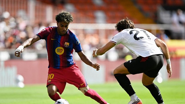 Soccer Football - LaLiga - Valencia v FC Barcelona - Estadio de Mestalla, Valencia, Spain - September 6, 2026 FC Barcelona's Lamine Yamal in action with Valencia's Jesus Vazquez REUTERS/Pablo Morano