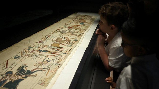 School children look at a section of the Bayeux Tapestry depicting King Harolds death during the press preview at the British Museum In London, Britain, September 7, 2026.  REUTERS/Suzanne Plunkett