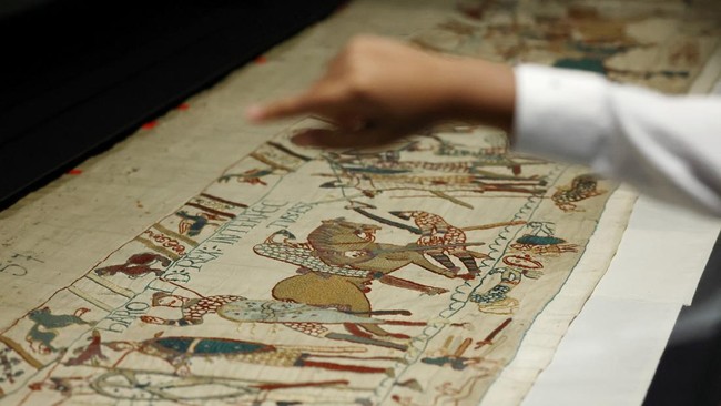 A young boy points to look at a section of the Bayeux Tapestry depicting King Harolds death during the press preview at the British Museum In London, Britain, September 7, 2026.  REUTERS/Suzanne Plunkett