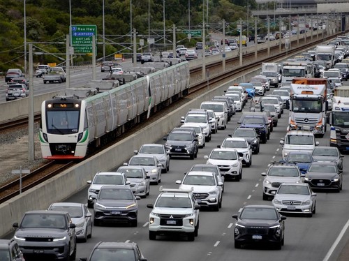 This picture shows a train heading toward Perth's central business district as cars commute alongside during the busy hours on March 23, 2026. Western Australia's government says there has been a big spike in the number of people using public transpo