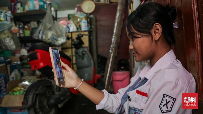 Sejumlah pelajar mengikuti Pembelajaran Jarak Jauh (PJJ) dari rumah setelah sebaran abu vulkanik Gunung Anak Krakatau terdeteksi mencapai wilayah Jakarta dan Bogor, Senin (7/9). (CNN Indonesia/Febria Adha L)