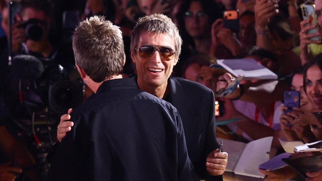 Liam Gallagher embraces Noel Gallagher on the red carpet during arrivals for the screening of the film