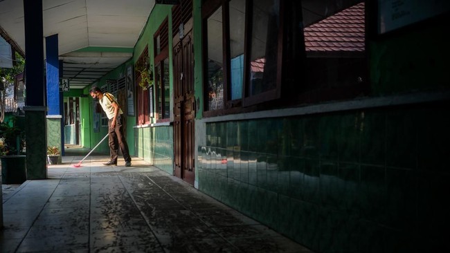 Penjaga sekolah membersihkan lantai dari abu vulkanik Gunung Anak Krakatau di SMP Negeri 1 Kalianda, Kabupaten Lampung Selatan, Lampung, Senin (7/9/2026). Pembersihan dilakukan untuk mencegah penumpukan abu vulkanik dan mempersiapkan sekolah jika pem