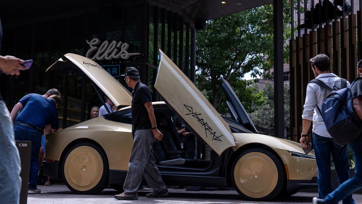 People examine a gold-colored Tesla Cybercab parked outside a bar in downtown ahead of an event in Austin, Texas, U.S. September 3, 2026.  REUTERS/Kaylee Greenlee