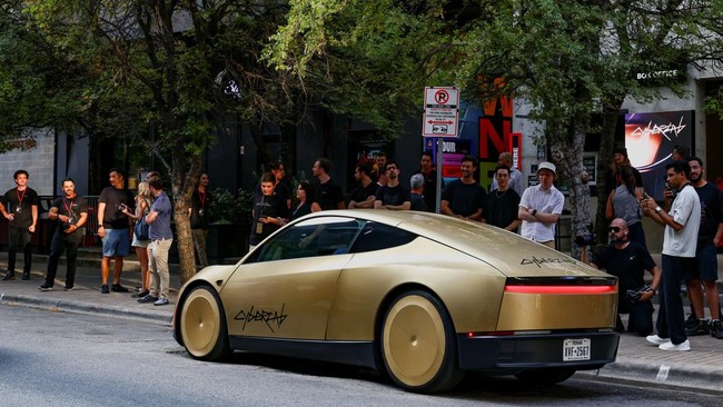 People look as a gold-colored Tesla Cybercab arrives for an event in downtown Austin, Texas, U.S., September 3, 2026.  REUTERS/Kaylee Greenlee