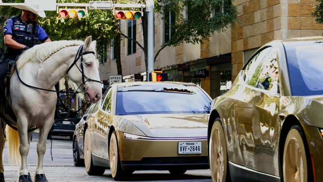 Mounted police patrols as gold-colored Tesla Cybercabs arrive for an event in downtown Austin, Texas, U.S., September 3, 2026.  REUTERS/Kaylee Greenlee