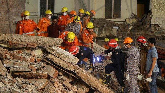 National Disaster Response Force (NDRF) personnel and firefighters look for survivors using light from a torch, at the scene of a building collapse, in New Delhi, India, September 6, 2026. REUTERS/Francis Mascarenhas
