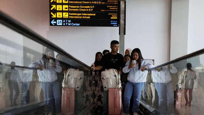 Passengers stand on an escalator as Soekarno-Hatta International Airport reopened following the eruption of Mount Anak Krakatau, in Tangerang, near Jakarta, Indonesia, September 8, 2026. REUTERS/Ajeng Dinar Ulfiana