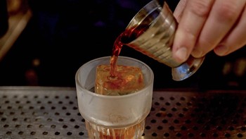 A spirit is poured over Japanese ice in a glass at Bar Bellamy in the Melbourne suburb of Carlton, on July 29, 2026.
