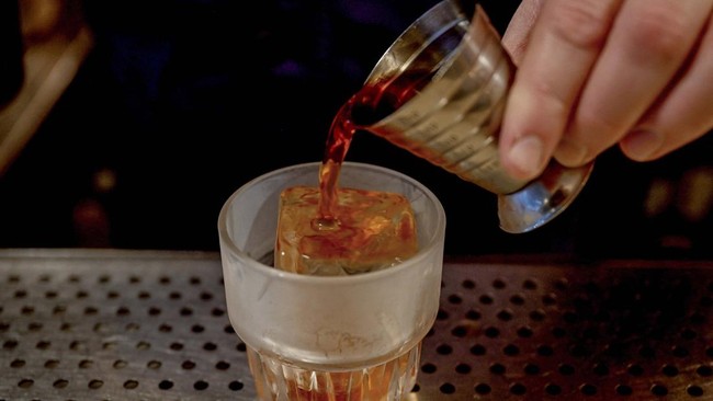 A spirit is poured over Japanese ice in a glass at Bar Bellamy in the Melbourne suburb of Carlton, on July 29, 2026.