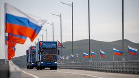 In this handout image released by the Russian Transport Ministry on September 7, 2026, national flags of Russia wave in the wind and North Korean trucks cross the new Russia-North Korea road bridge over the Tumen River, during the opening ceremony. (