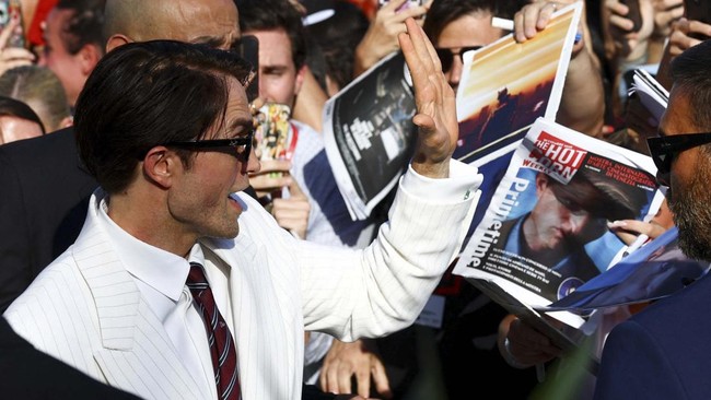 Cast member Robert Pattinson interacts with fans on the red carpet during arrivals for the screening of the movie