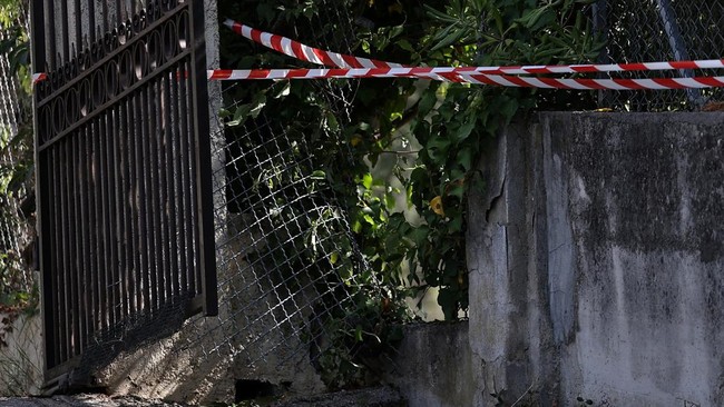 Police line tape used to secure the area is seen near a hole in the outer fence of the Renoir Museum after four paintings were stolen by thieves in an early-morning break-in, with two recovered nearby, in Cagnes-sur-Mer, on the French Riviera, France