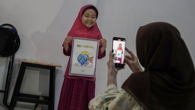 Orang tua merekam aktivitas anaknya yang mengikuti penerapan pembelajaran jarak jauh (PJJ) di Kota Pekanbaru, Riau, Rabu (9/9/2026). Pemerintah Kota Pekanbaru kembali menerapkan sistem pembelajaran jarak jauh bagi peserta didik tingkat PAUD hingga SM