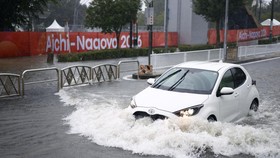 A car drives along a road flooded by heavy rain while banners for the Aichi-Nagoya Asian Games are visible in the background in Nagoya, central Japan September 8, 2026, in this photo taken by Kyodo. Mandatory credit Kyodo/via REUTERS ATTENTION EDITOR