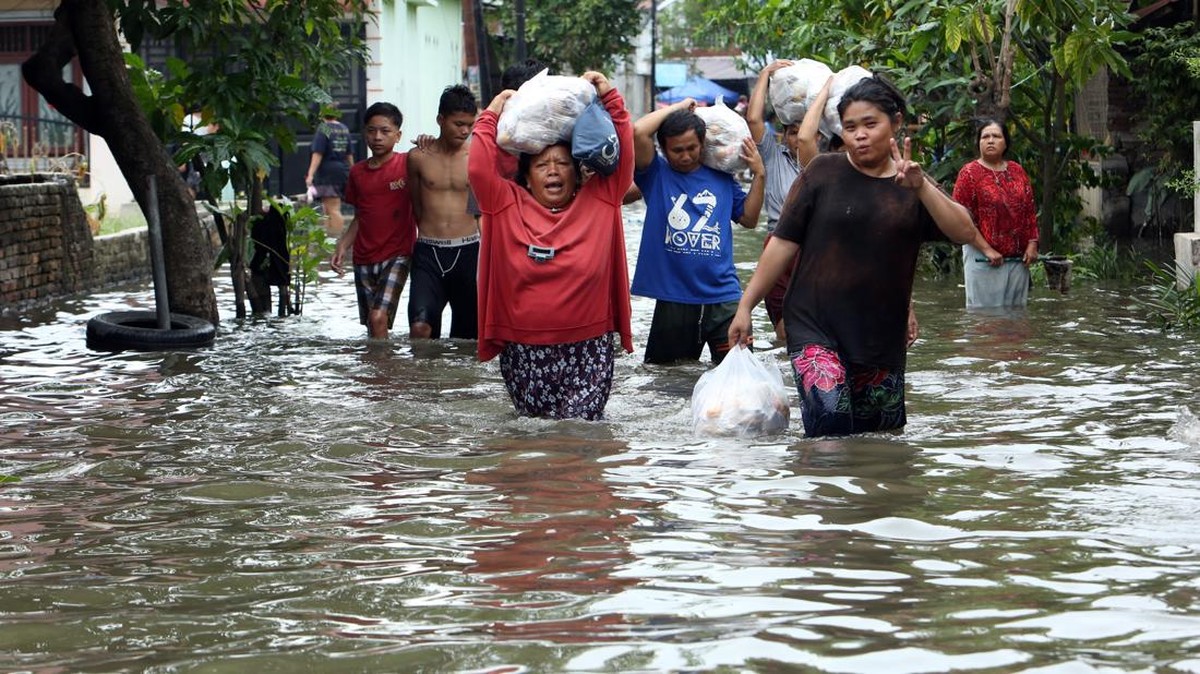 Warga berjalan menerobos banjir di Martubung, Kecamatan Medan Labuhan, Medan, Sumatera Utara, Kamis (10/9/2026). Data Badan Penanggulangan Bencana Daerah (BPBD) Kota Medan menyebutkan sebanyak 1770 rumah atau 2050 kepala keluarga (KK) terdampak banji