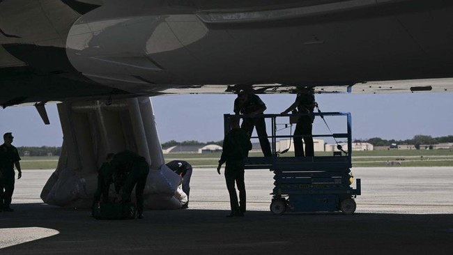 Personnel work near Air Force One after the emergency slide of the new Air Force One is deployed ahead of US President Donald Trumps departure for the Republican National Committee (RNC) midterm convention, at Joint Base Andrews in Maryland on Septem