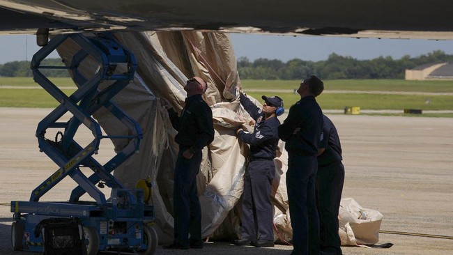 JOINT BASE ANDREWS, MARYLAND - SEPTEMBER 09: Crew members work on an inflated escape device extending from the side of the Boeing VC-25B